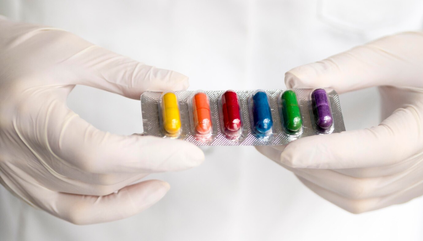 high-angle-doctor-holding-rainbow-colored-pills-foil_23-2148533452