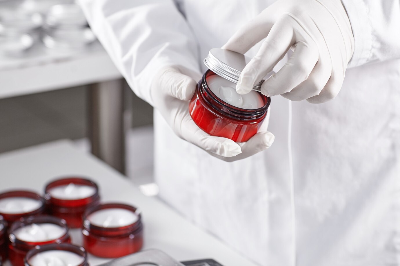 worker-filling-container-with-cream-cosmetic-factory_273609-13419